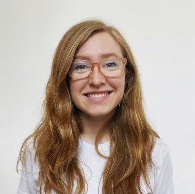 Photo of Jen Goertzen, woman looking into camera, smiling, she has long red hair and is wearing glasses